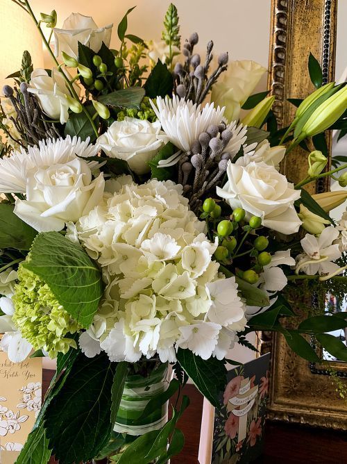White sympathy flower arrangement for Fairview, TN Funeral Services with roses, lilies, and greenery