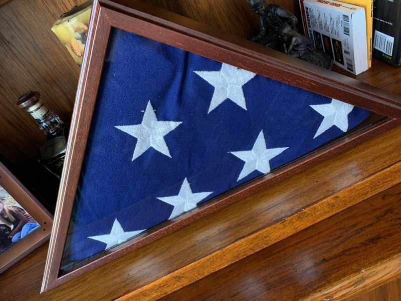 Folded American flag case for Fairview, TN Veteran Services displayed on a wooden shelf with keepsakes