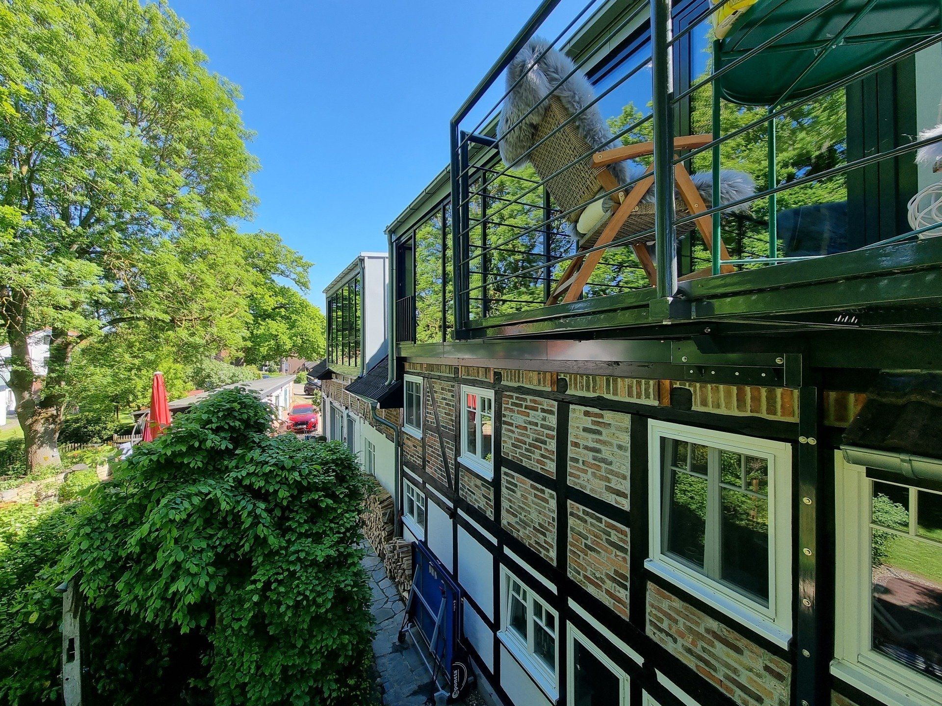 An der Seite eines Gebäudes befindet sich ein Balkon mit einem Stuhl darauf.
