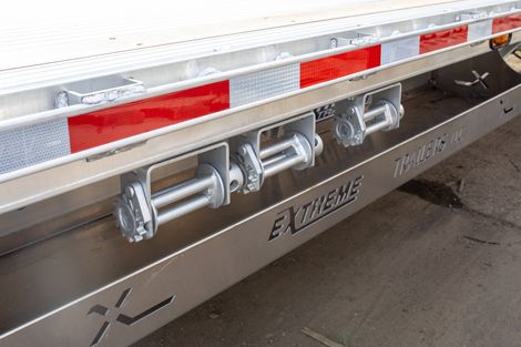 Three winches mounted on the side of a trailer with red reflective tape. 