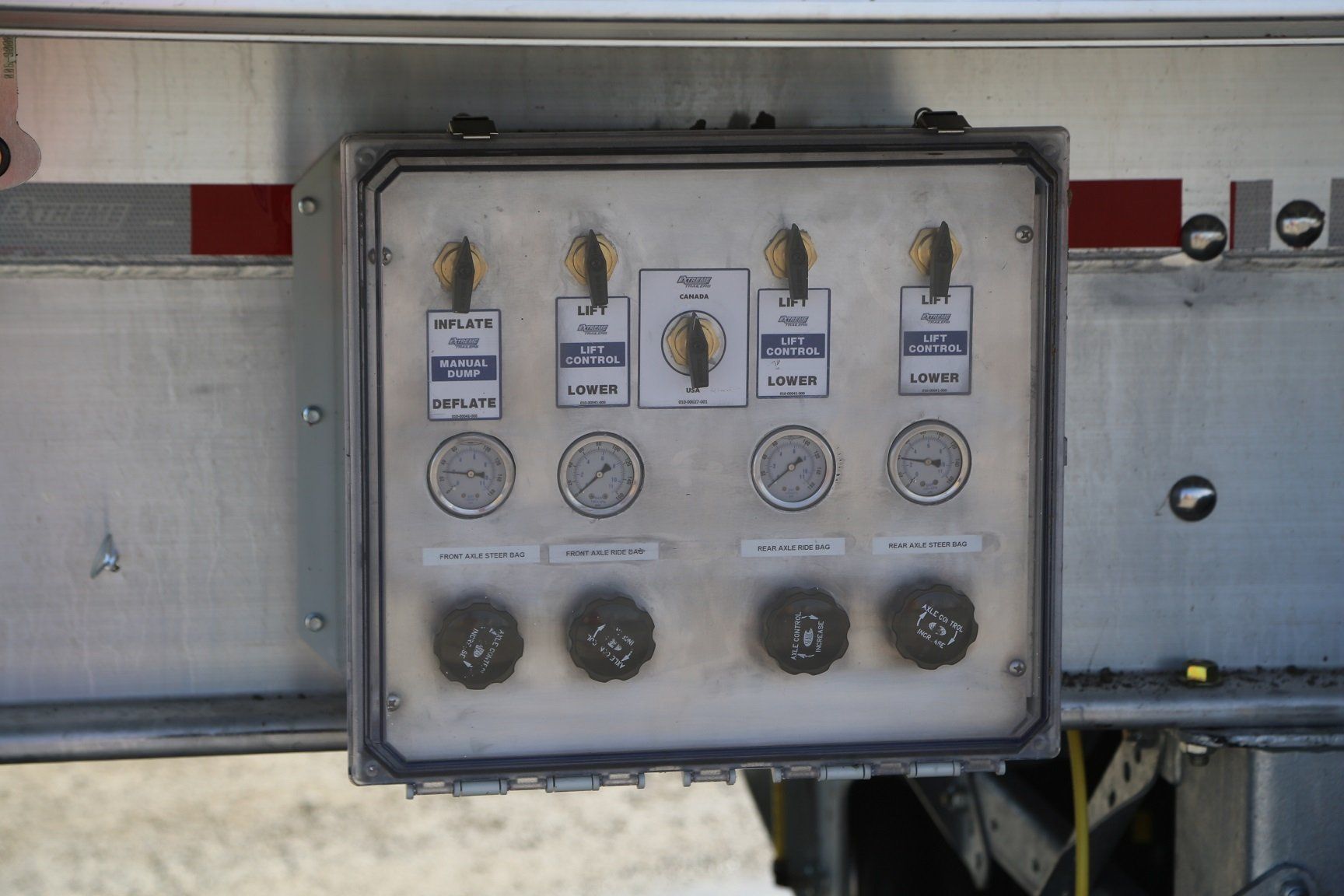 Control panel with gauges and levers on the side of a trailer.