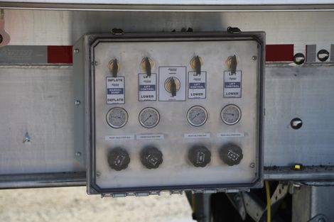 Control panel with gauges and levers on the side of a trailer.