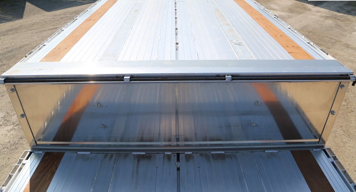 A flatbed truck trailer with an open aluminum bulkhead.