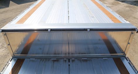 A flatbed truck trailer with an open aluminum bulkhead.