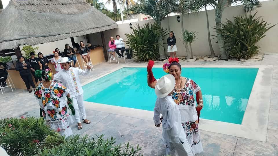 Un grupo de personas está bailando frente a una piscina.