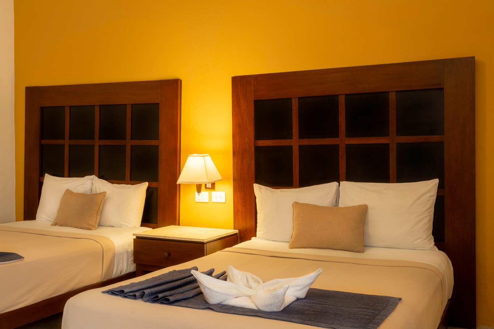 Una habitación de hotel con dos camas y una lámpara.