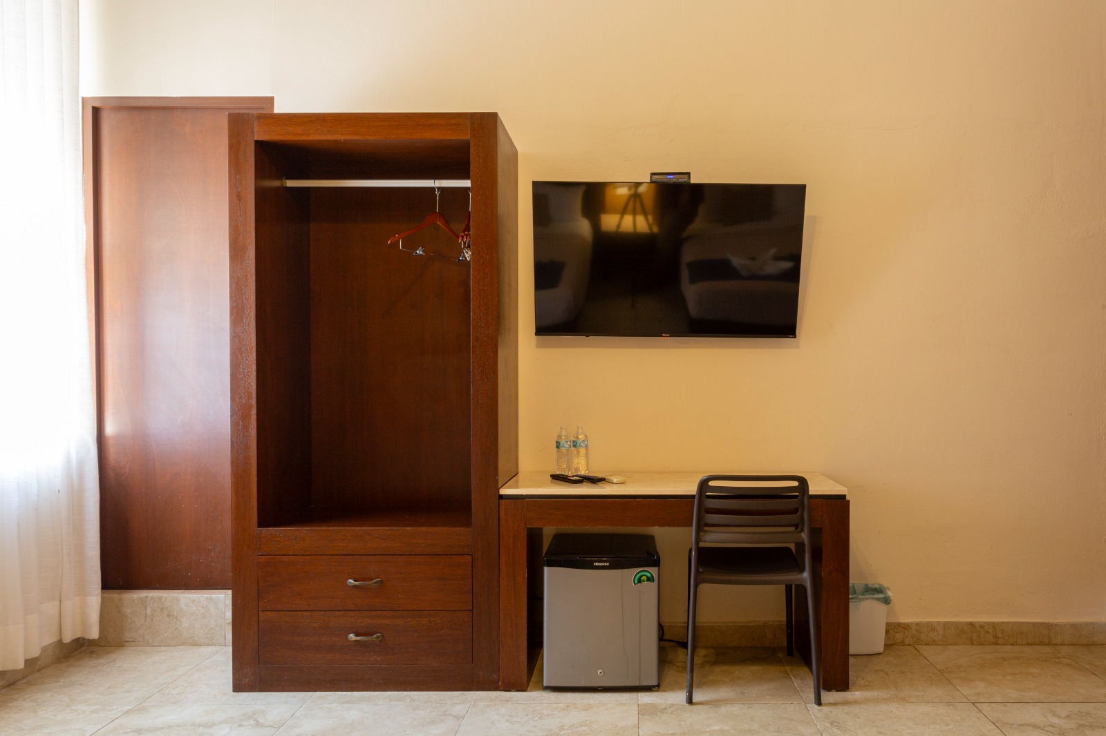 Una habitación de hotel con escritorio, silla y televisión.