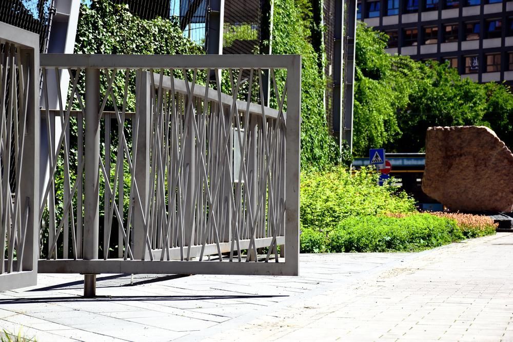 A Metal Fence Is Sitting On A Sidewalk In Front Of A Building — Rabbo's Fencing Services In Darwin City, NT