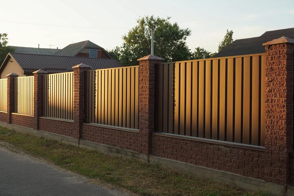 A Brick Fence With A Metal Fence In Front Of A House — Rabbo's Fencing Services In Casuarina, NT