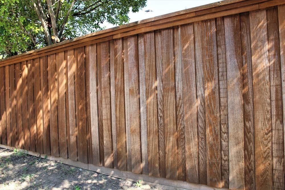 A Close Up Of A Wooden Fence With Trees In The Background — Rabbo's Fencing Services In Berry Springs, NT