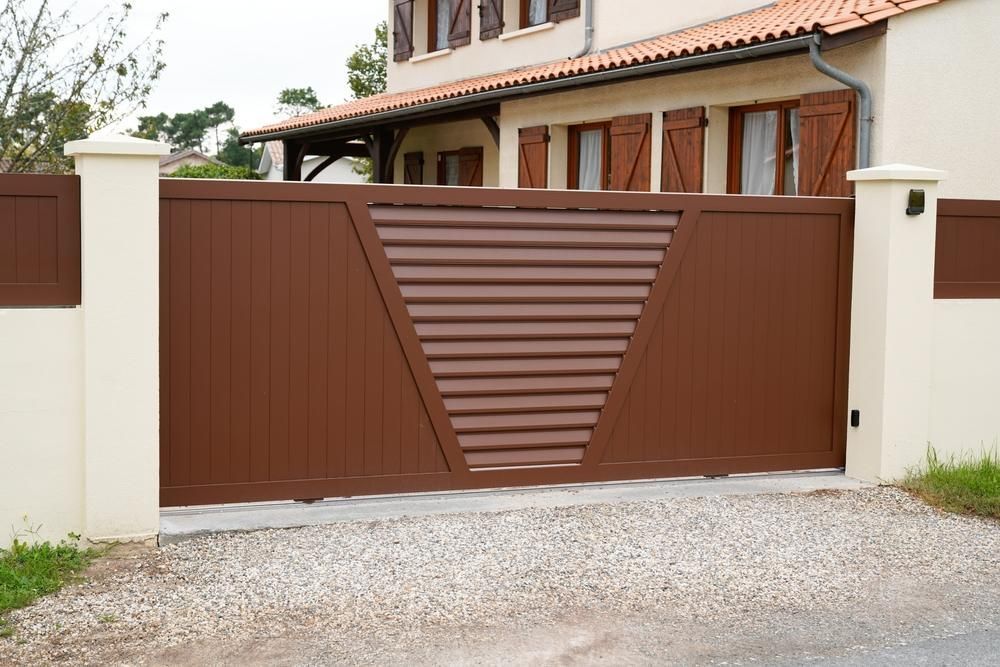A Brown Gate With A Triangle Design Is In Front Of A House — Rabbo's Fencing Services In Acacia Hills, NT