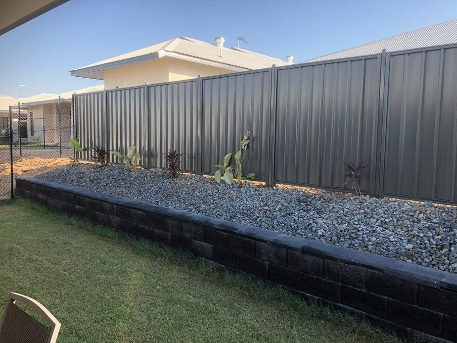 A Black Fence Surrounds A Gravel Area In A Backyard — Rabbo's Fencing Services In Pinelands, NT