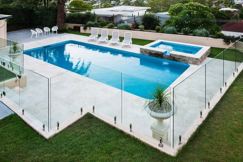 A Large Swimming Pool With A Glass Fence Around It — Rabbo's Fencing Services In Pinelands, NT