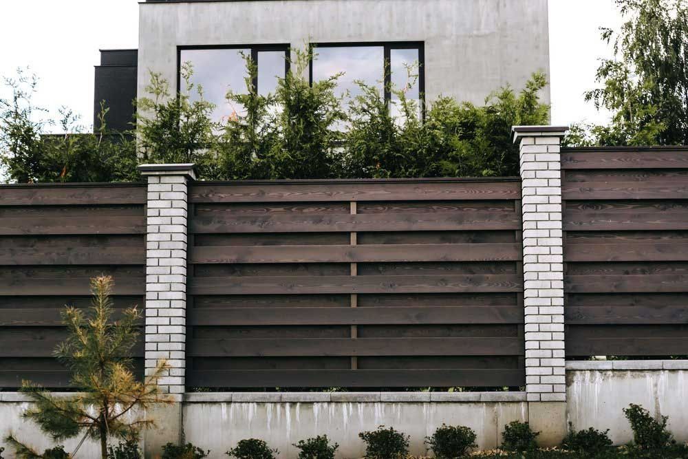 There Is A Wooden Fence In Front Of A House — Rabbo's Fencing Services In Pinelands, NT