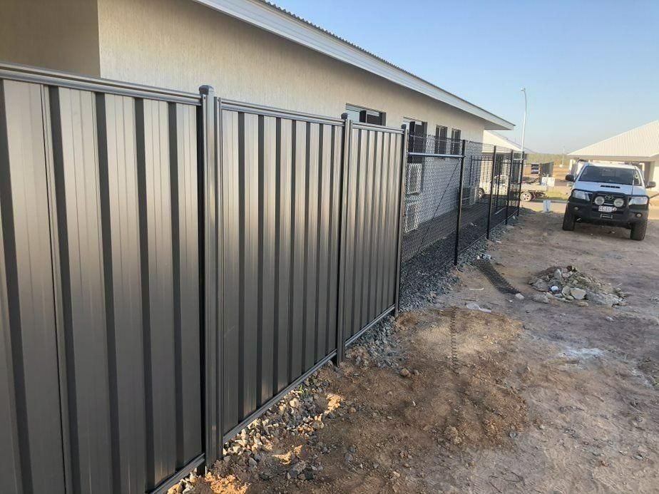 A Fence Is Being Built In Front Of A House — Rabbo's Fencing Services In Pinelands, NT