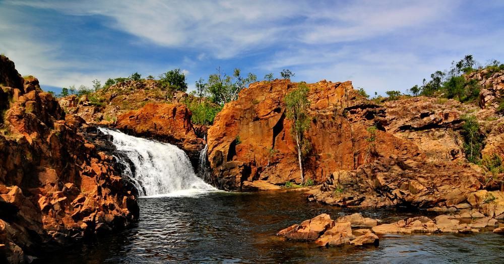 There Is A Waterfall In The Middle Of A River Surrounded By Rocks — Rabbo's Fencing Services In Katherine, NT