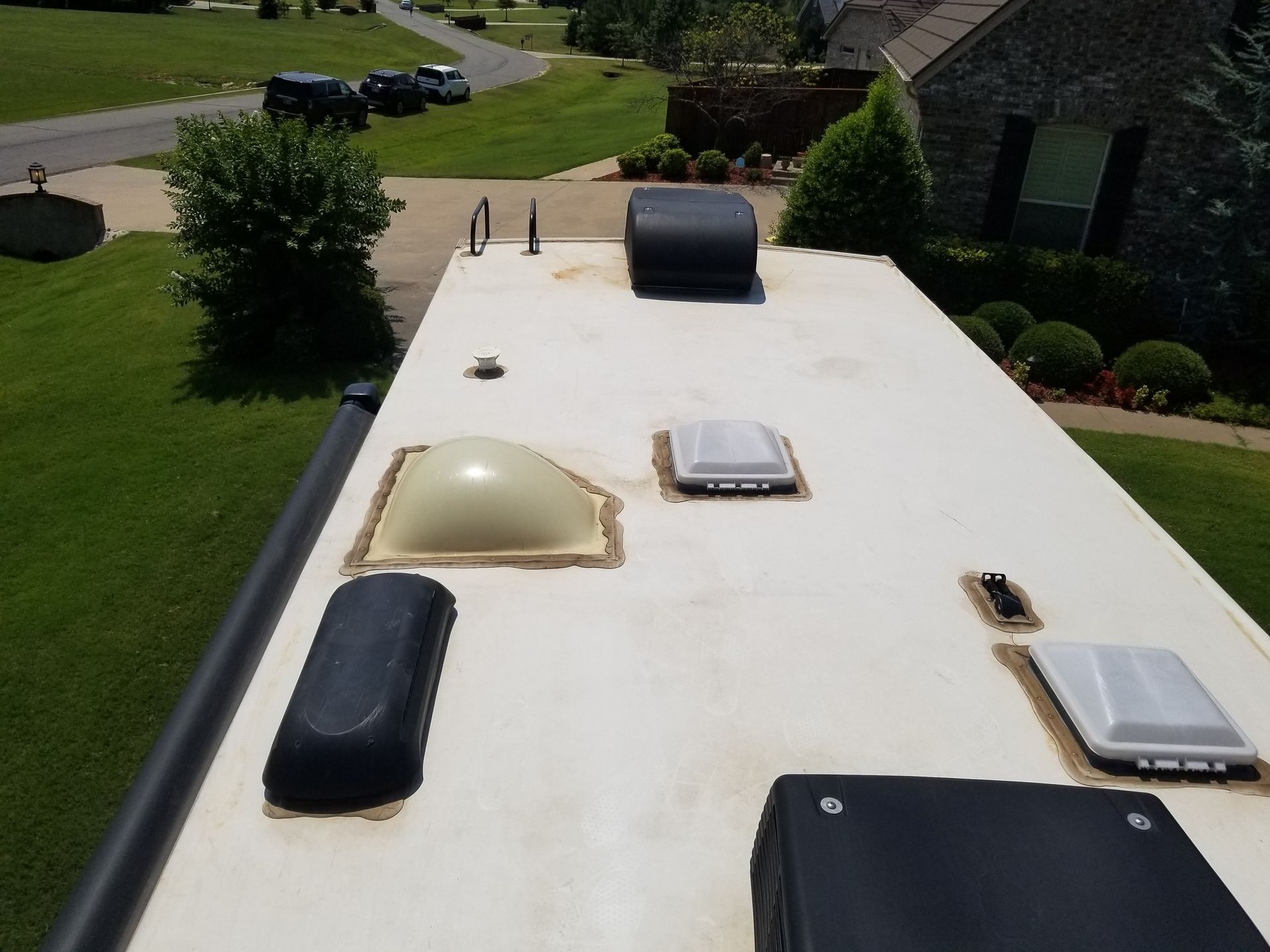 The roof of a rv has a few vents on it