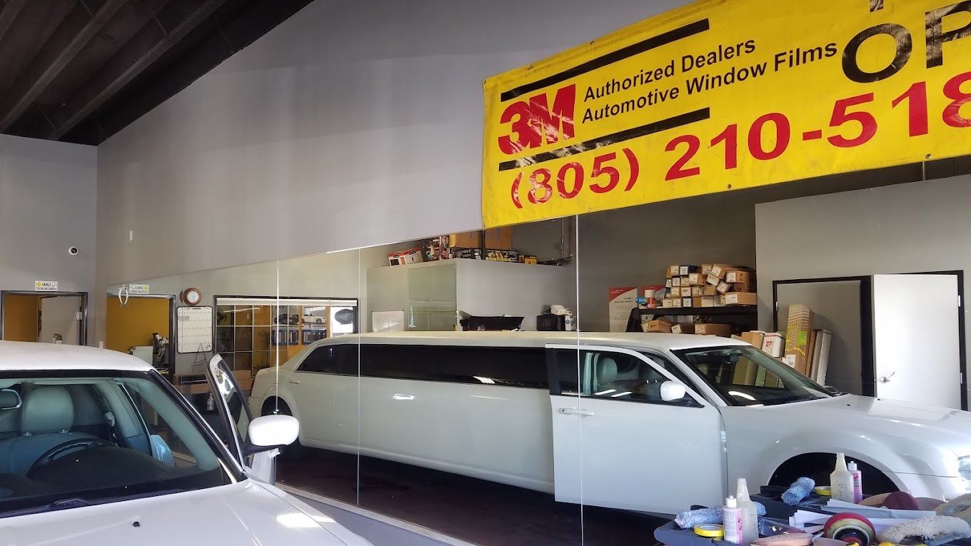 A limousine is parked in a garage under a 3m sign