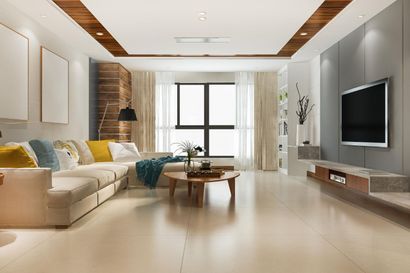 Modern living room with beige sofa, wood accents, wall-mounted TV, and large windows