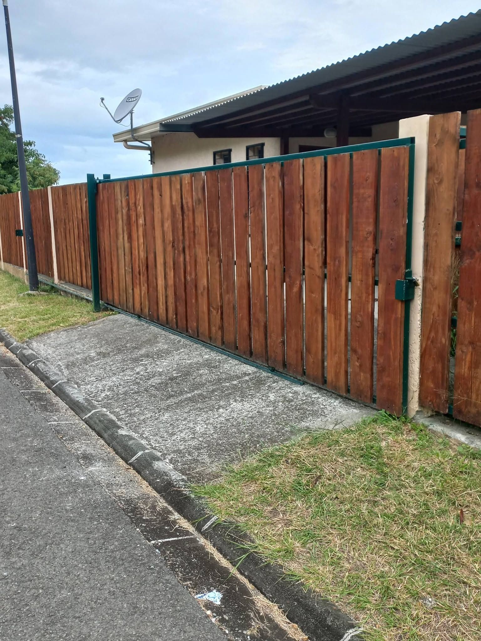 wood fence panel with integrated wood gate along a paved path