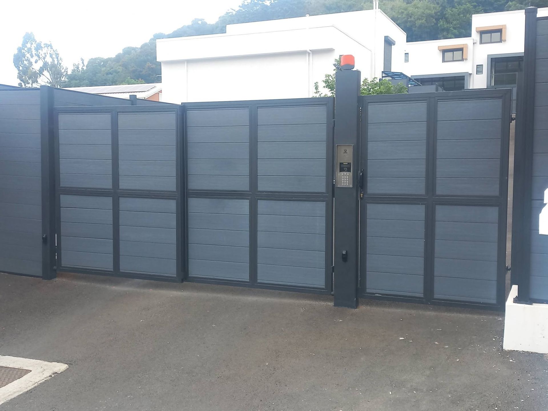 dark gray sliding/swing gate panel on a driveway