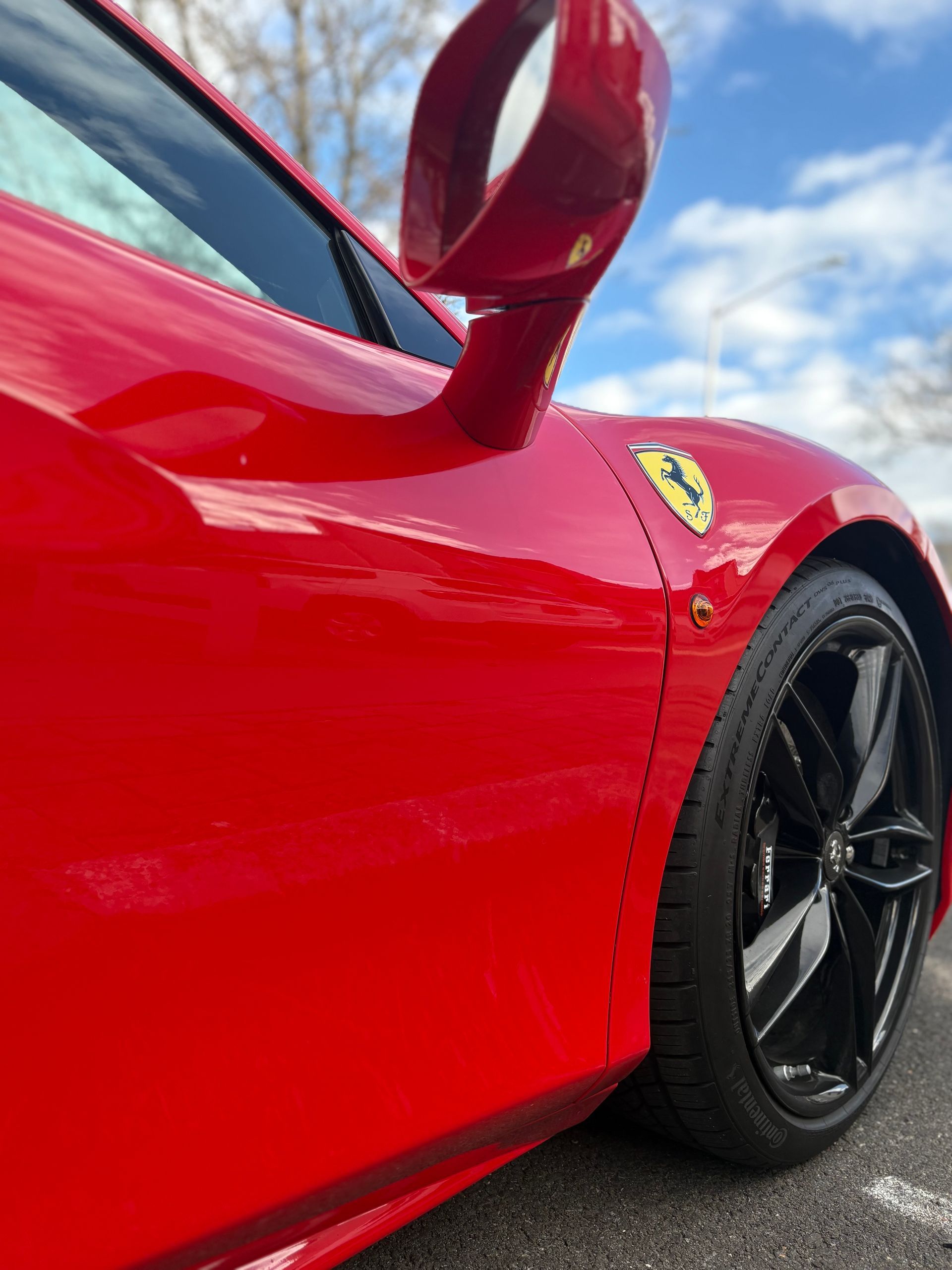 Red Ferrari sports car with black rims, side view, sunny day. | Honesty Automotive Repairs