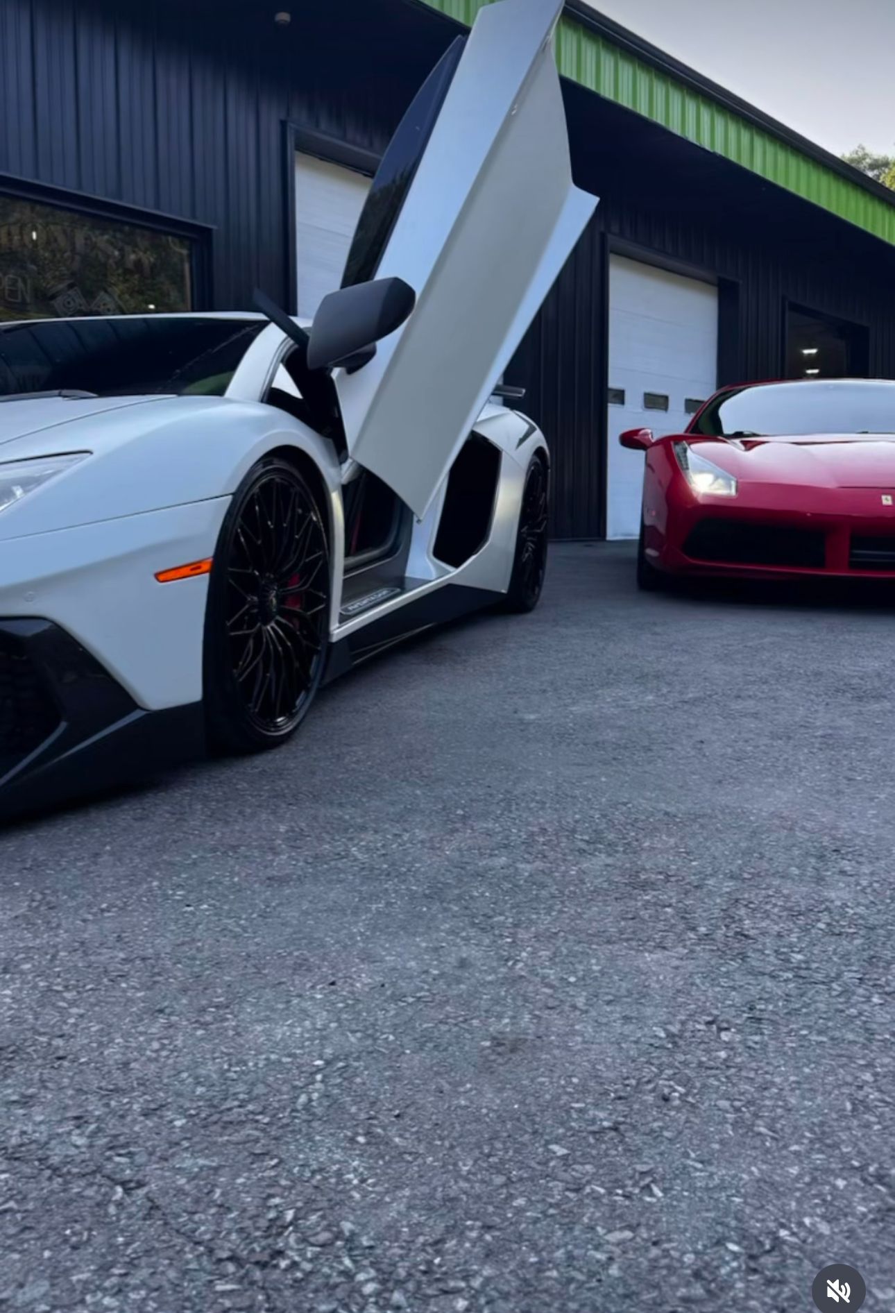 White Lamborghini with open door and red Ferrari parked on pavement in front of a garage. | Honesty Automotive Repairs