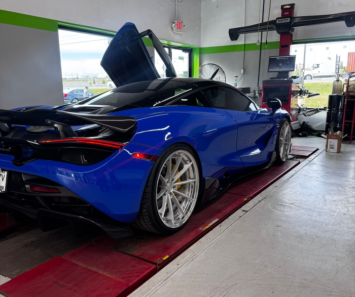 Blue McLaren sports car with doors open at a service station | Honesty Automotive Repairs