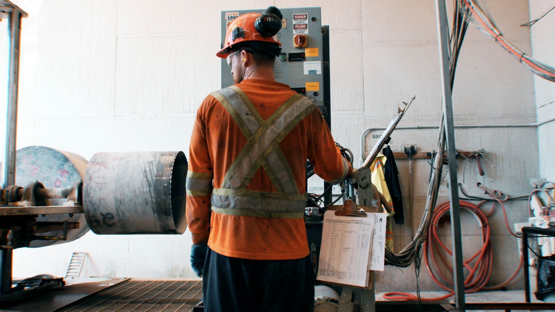 A man is working on a forklift in a warehouse.
