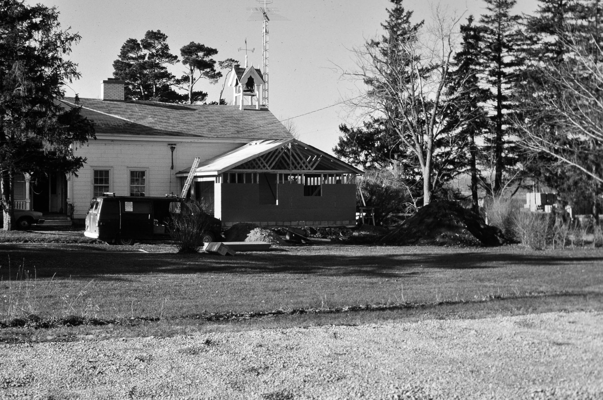 A black and white photo of a house surrounded by trees