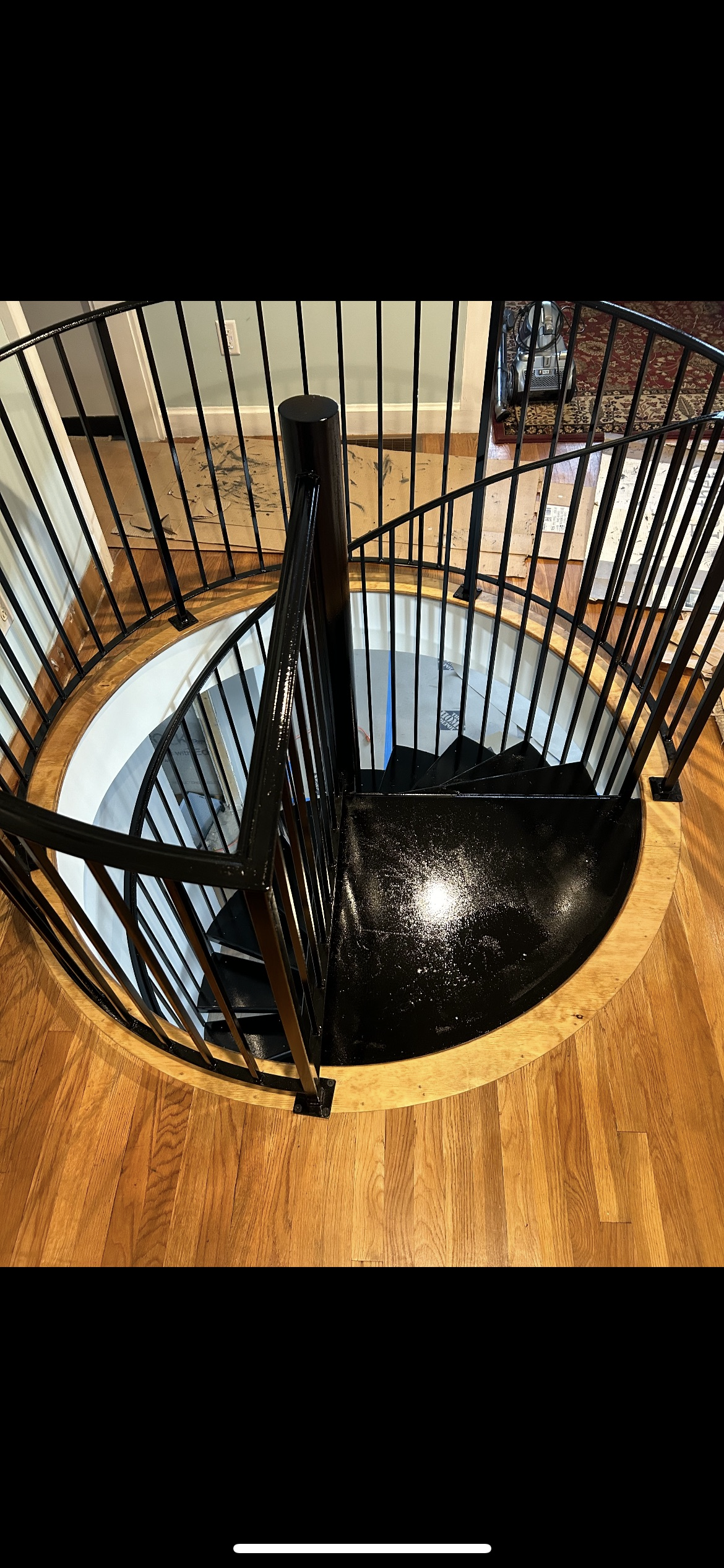 A spiral staircase with a wrought iron railing in a house.