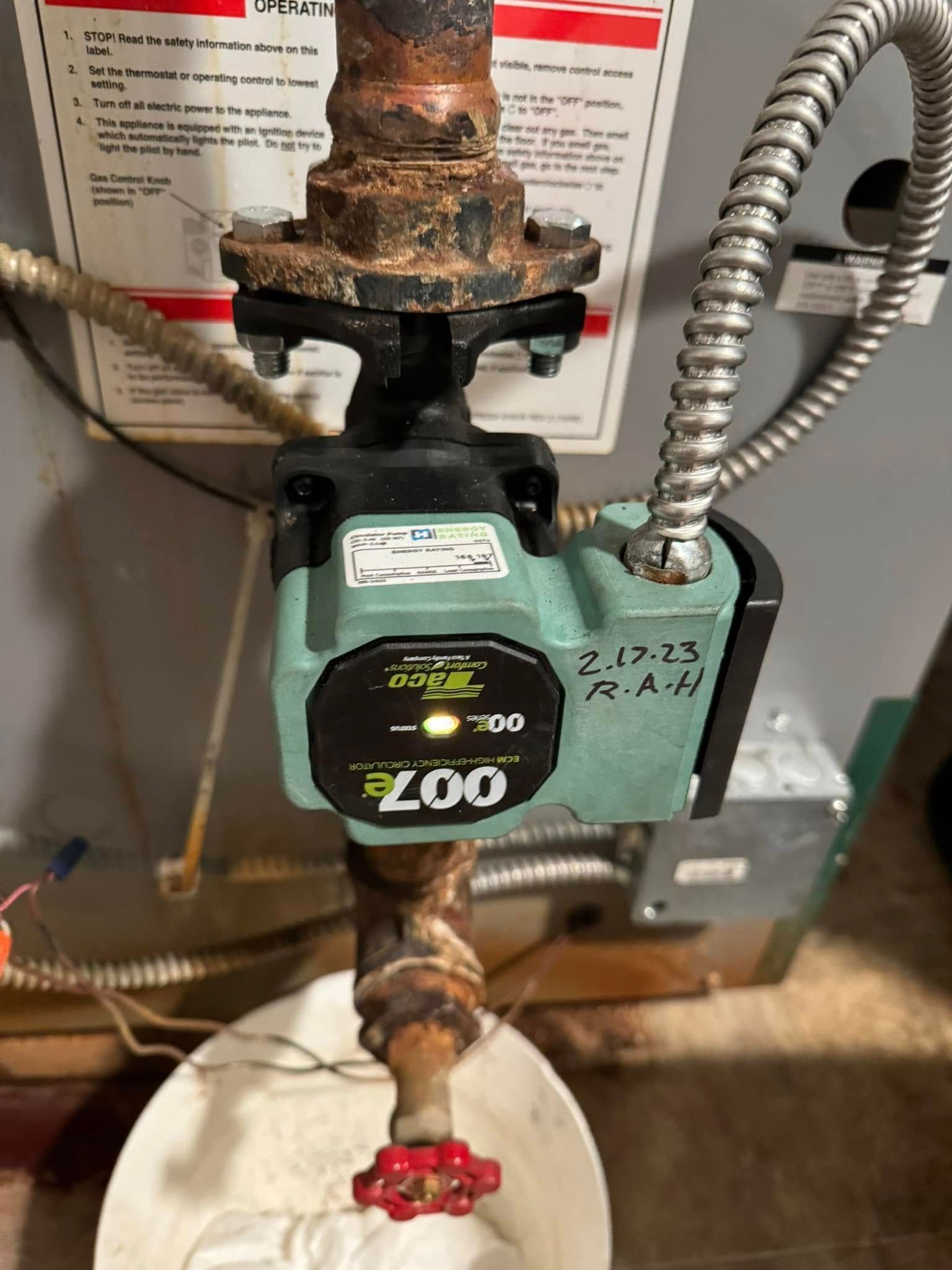 Green ZOO pump on a pipe with a red valve, connected to a water heater. Marked “2.12.23 R.A.H.”