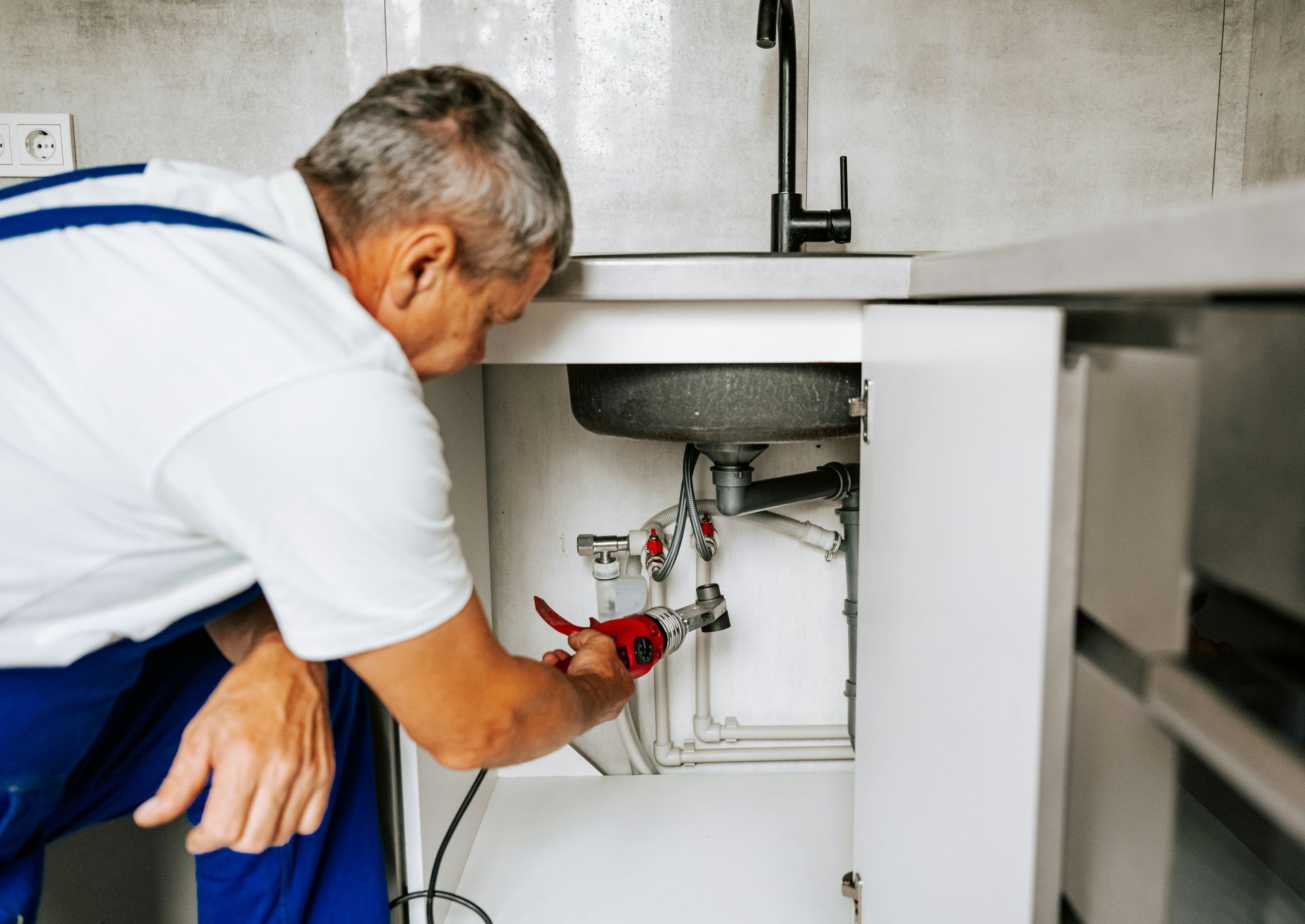 White radiator below a window next to a bed in a room.