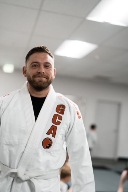 Man in white gi, smiling,