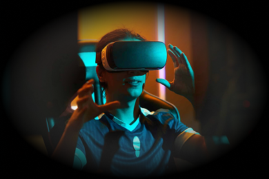 A person wearing a VR headset, gesturing with both hands in a dimly lit room with blue and orange ambient lighting.
