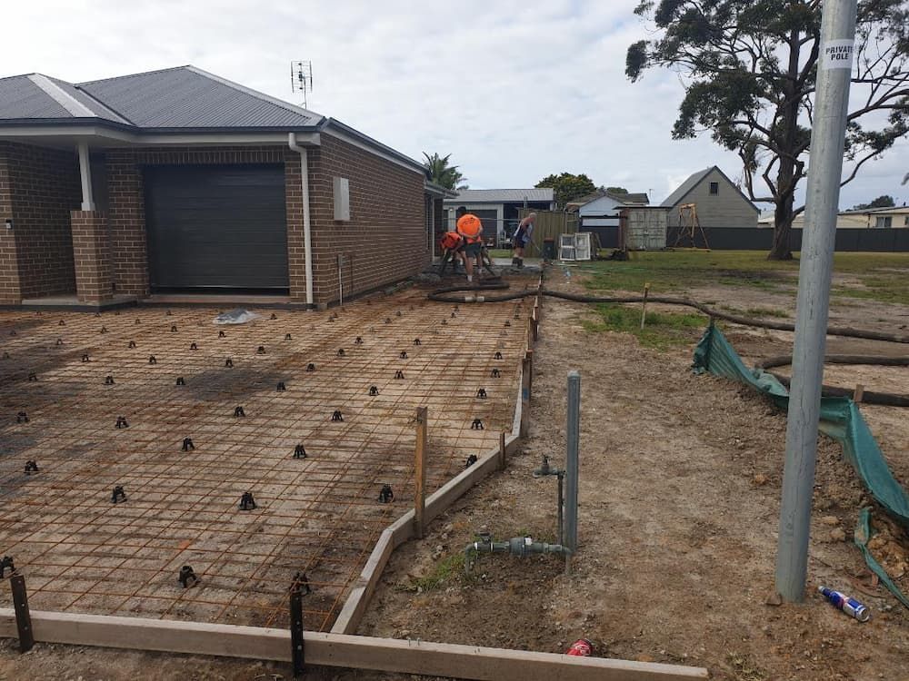 A Concrete Driveway Is Being Built In Front Of A Brick House — Turn It Crete in St Georges Basin, NSW