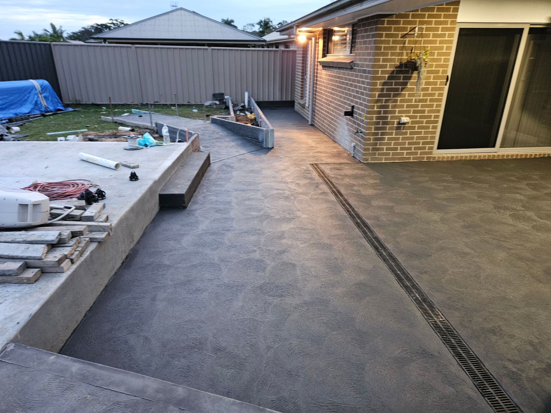 A Concrete Patio Next To A House With Tools On The Ground — Turn It Crete in Nowra, NSW