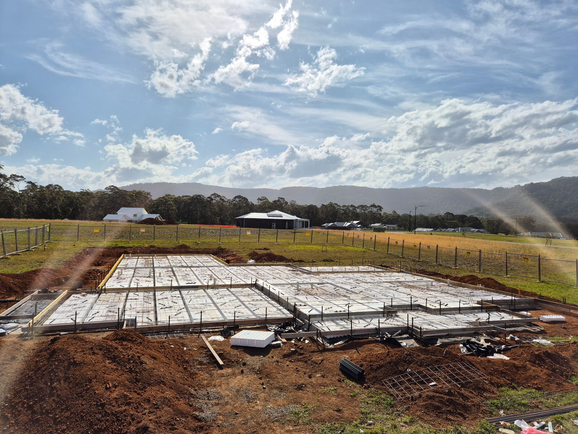 A Block Of Land With A House Slab And Mountains In The Background — Turn It Crete in St Georges Basin, NSW