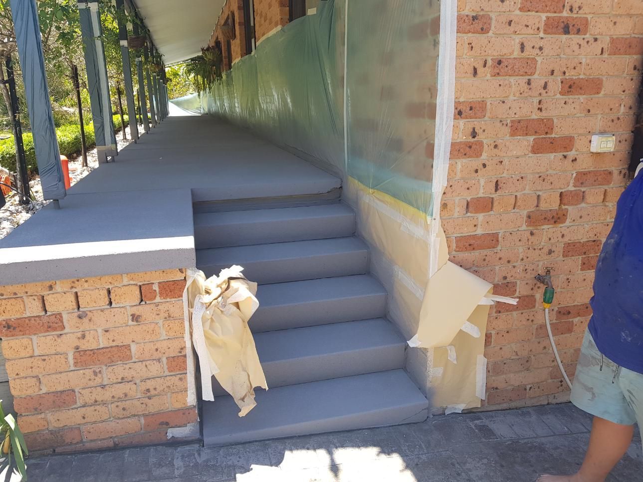A Man Is Painting The Stairs Of A Brick Building — Turn It Crete in St Georges Basin, NSW