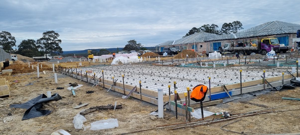 A Construction Site With A Lot Of Dirt And A House In The Background — Turn It Crete in St Georges Basin, NSW