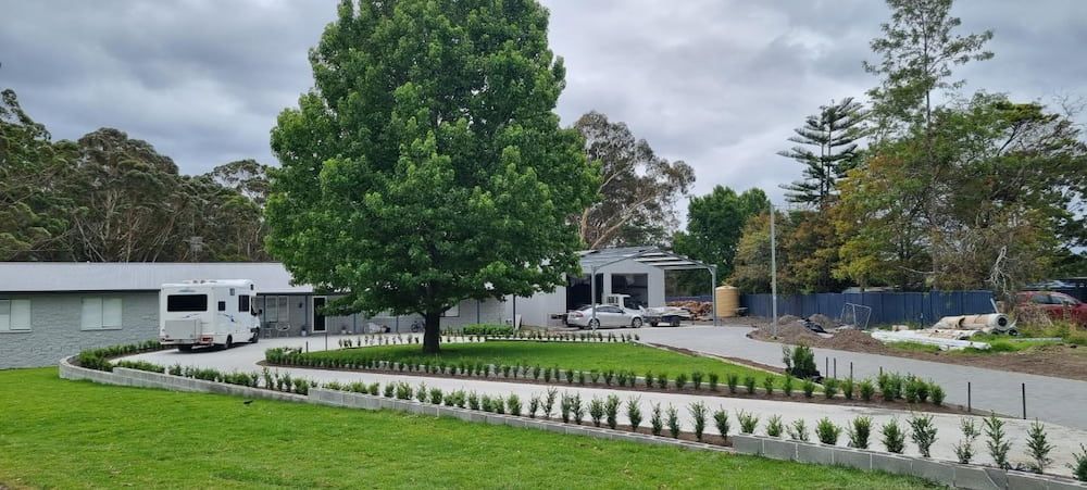A White Van Is Parked In Front Of A House With A Large Tree In The Yard — Turn It Crete in St Georges Basin, NSW
