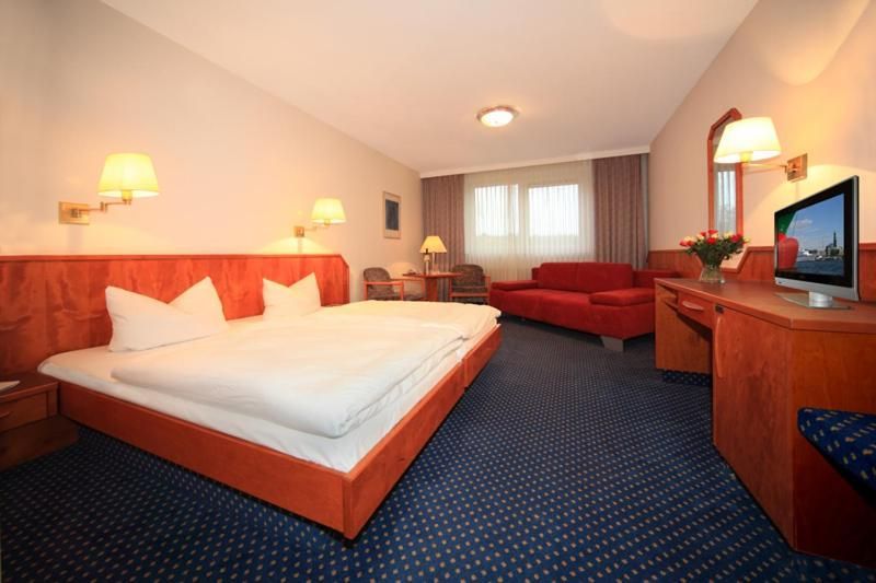 Ein Hotelzimmer mit drei Betten und einem Tisch