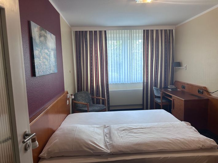 Ein Hotelzimmer mit einem Einzelbett und einem Tisch