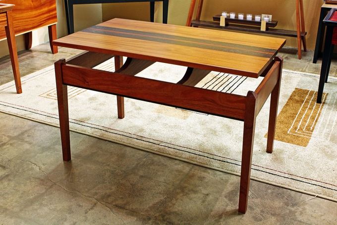 A wooden coffee table with a drawer underneath it