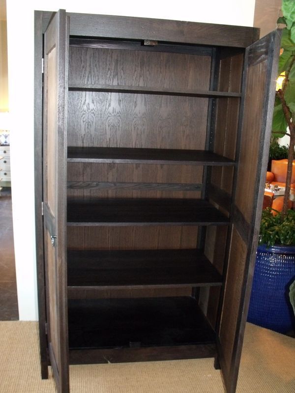 A wooden cabinet with the doors open and shelves empty