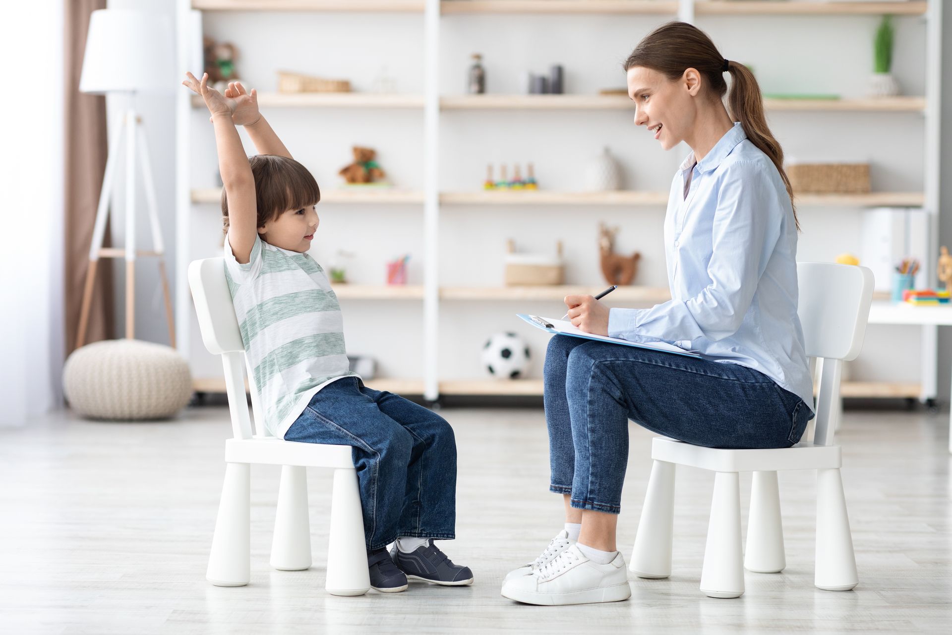 A woman is sitting in a chair with a child in a chair.