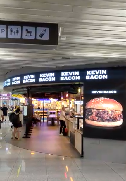 Restaurante Kevin Bacon en una terminal de aeropuerto muy iluminada. 