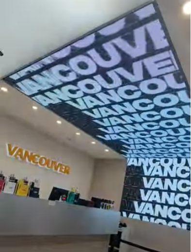 Fotografía del interior de una tienda con el letrero «VANCOUVER». El techo y la pared presentan el texto «VANCOUVER»