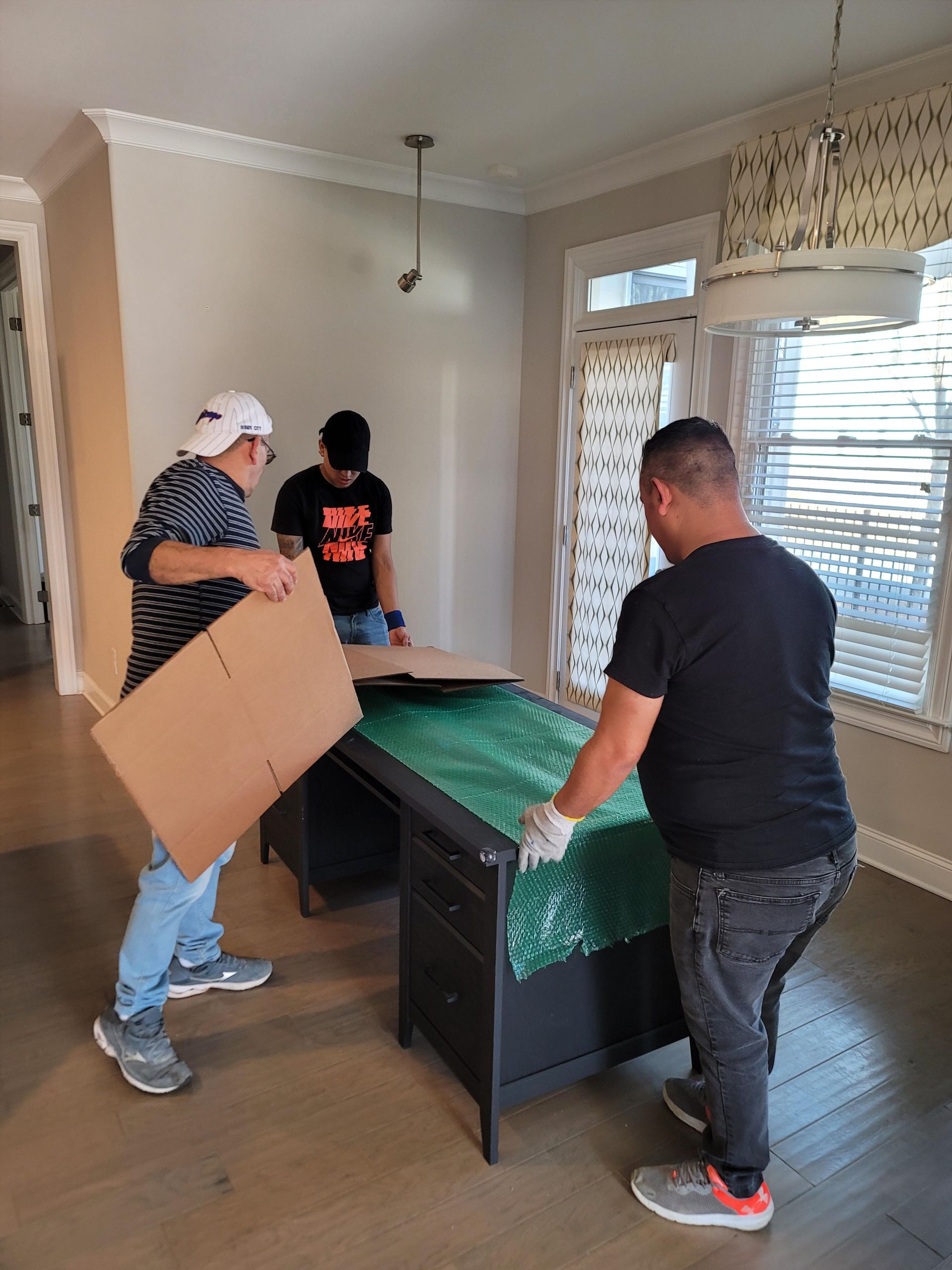 A group of men are moving a desk in a living room.