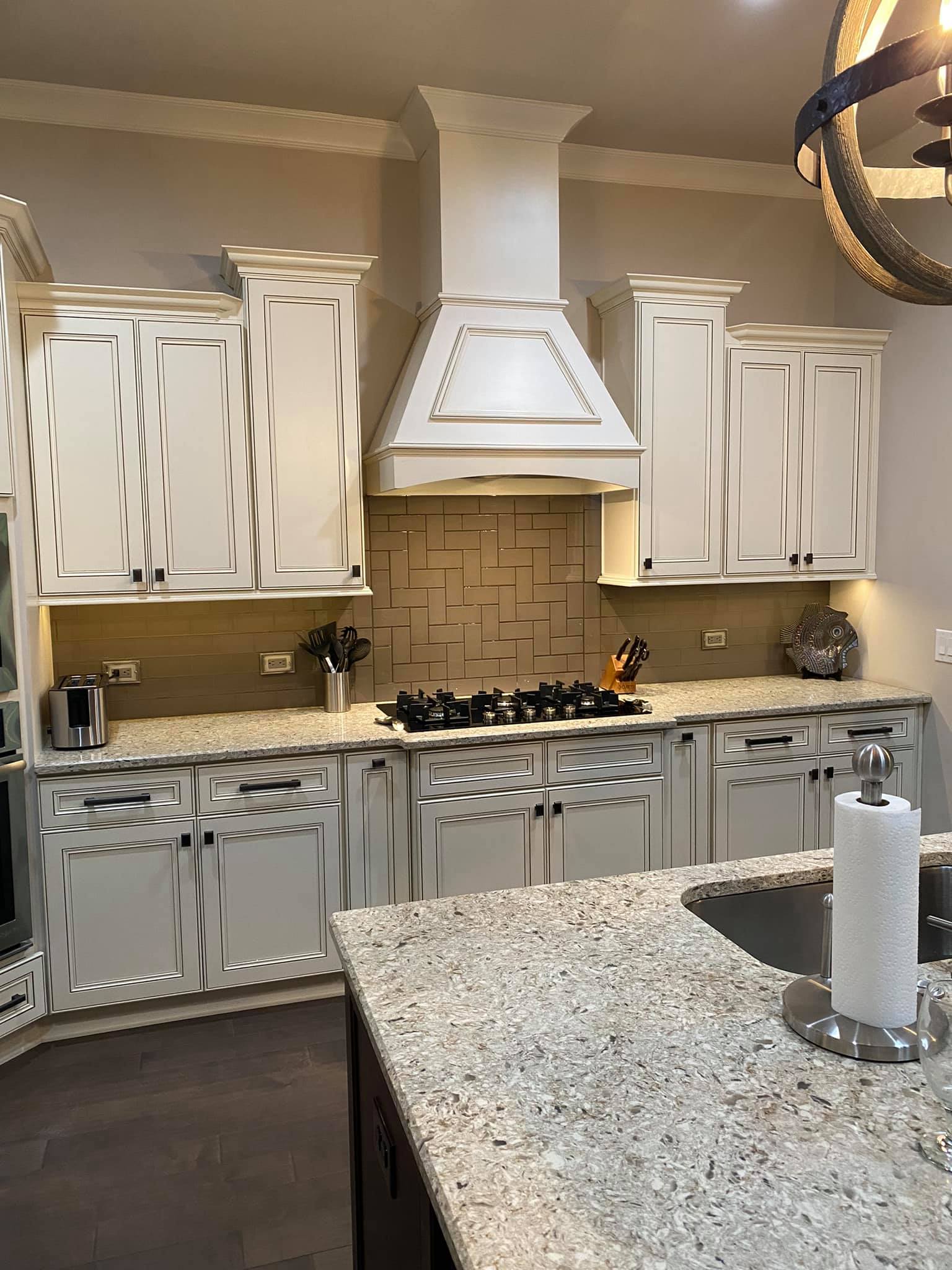 A kitchen with white cabinets , granite counter tops , a stove and a sink.